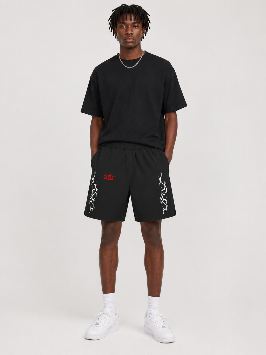 Person wearing a black t-shirt and shorts with a logo on a white background